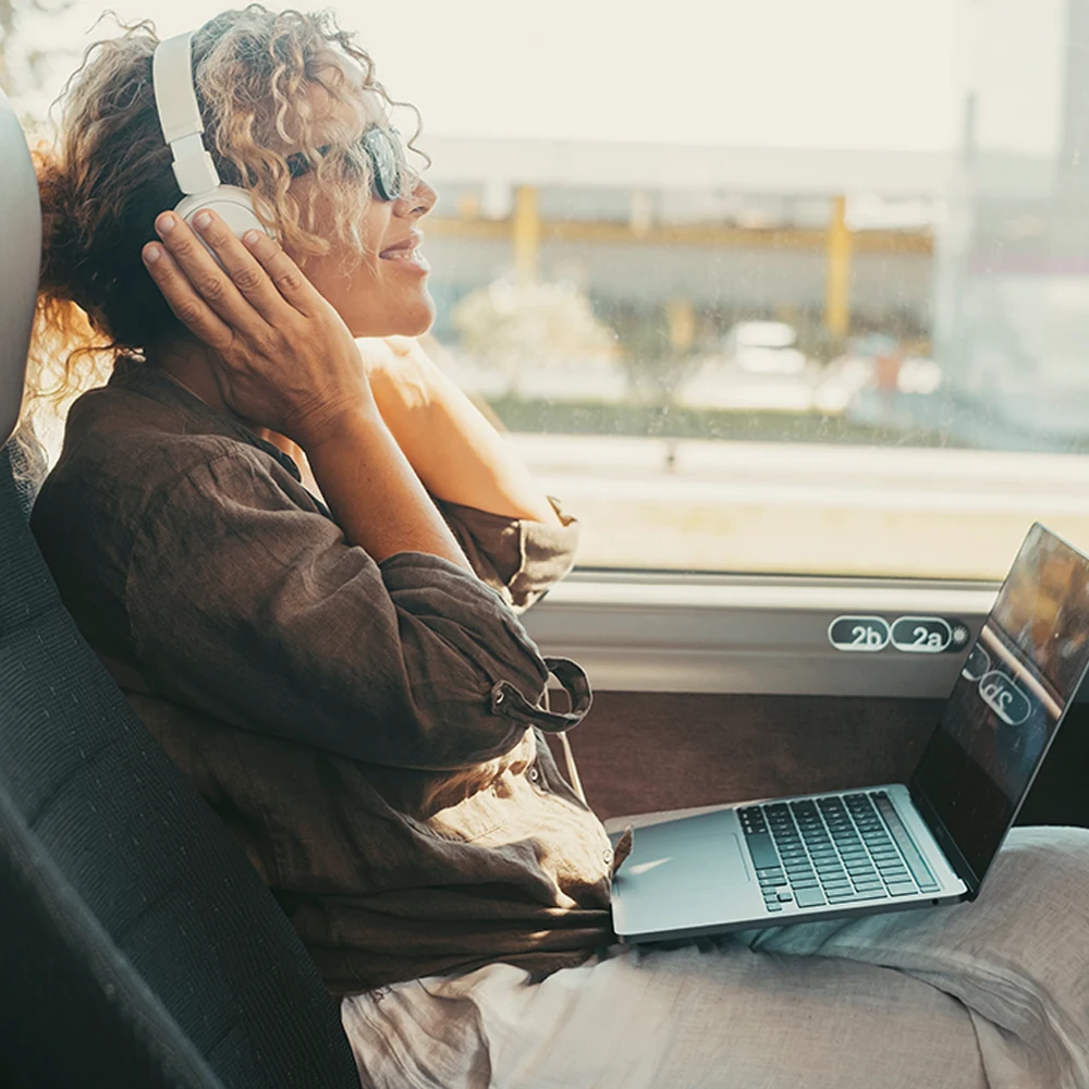 Femme souriante qui écoute de la musique en car Femme souriante qui écoute de la musique en car